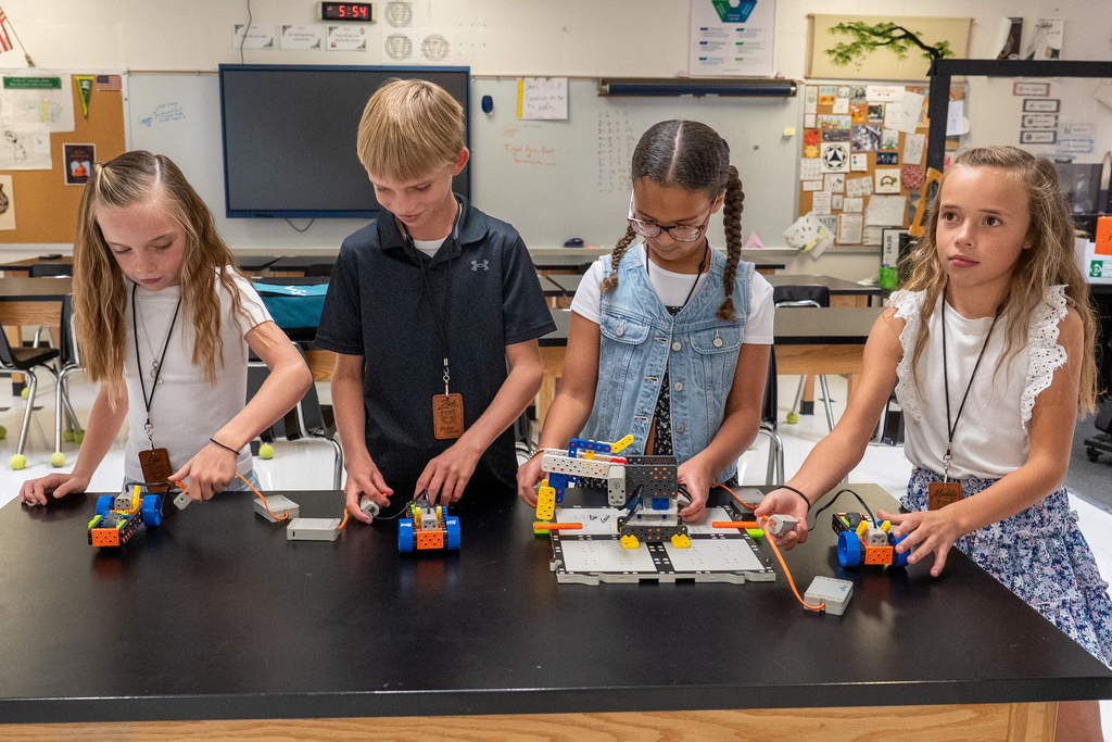 4 students demonstrating their coding and robotics work