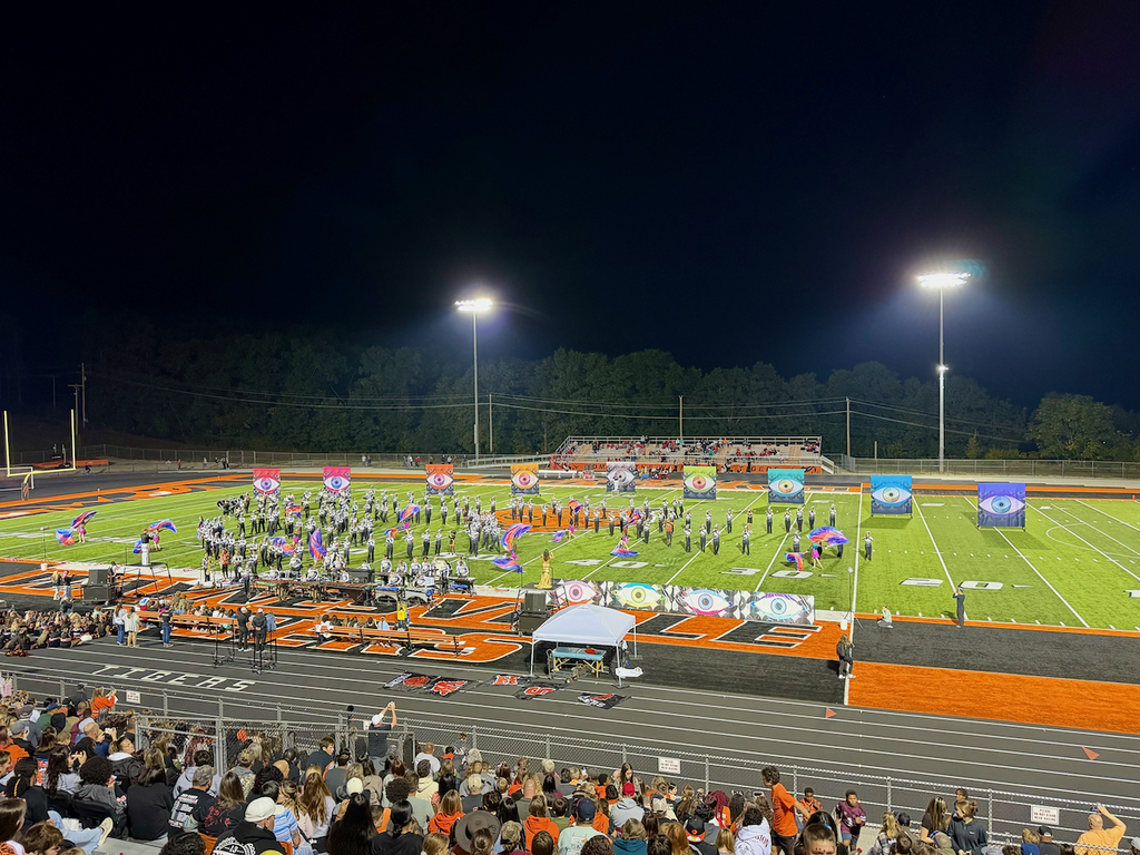 Marching band on a football field from up in the stands 
