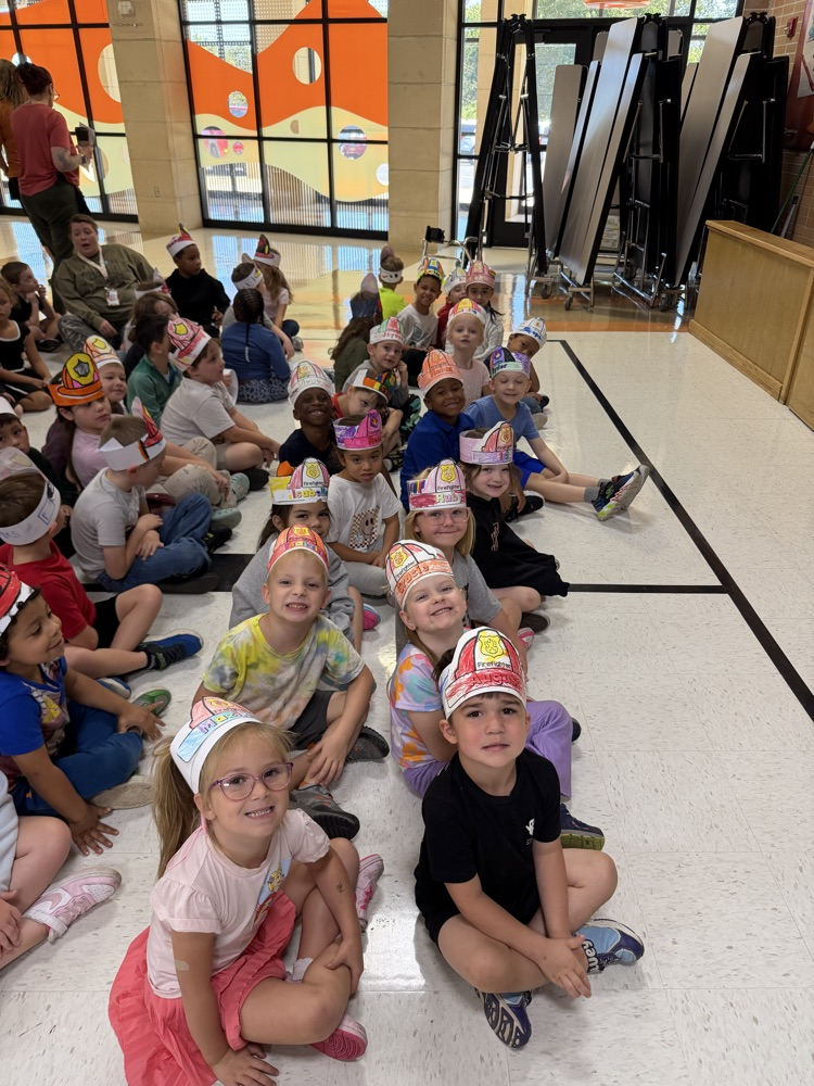 20 students sitting with paper colored Fire headbands on their heads