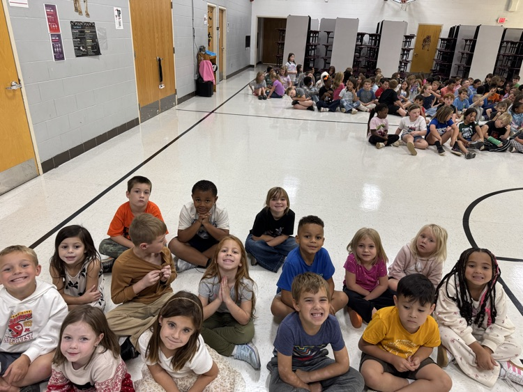 15 students sitting together and waiting for their fire assembly.