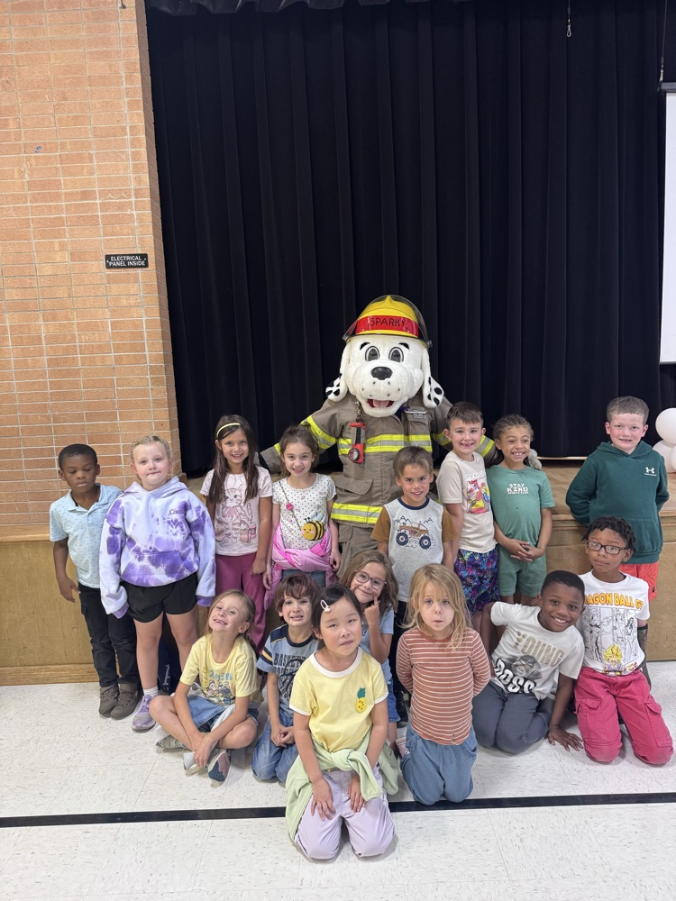15 students standing with the fire dog (mascot) posing for a picture.