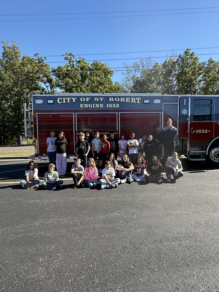 23 students and 1 teacher posing in front of the St. Robert Fire Truck.