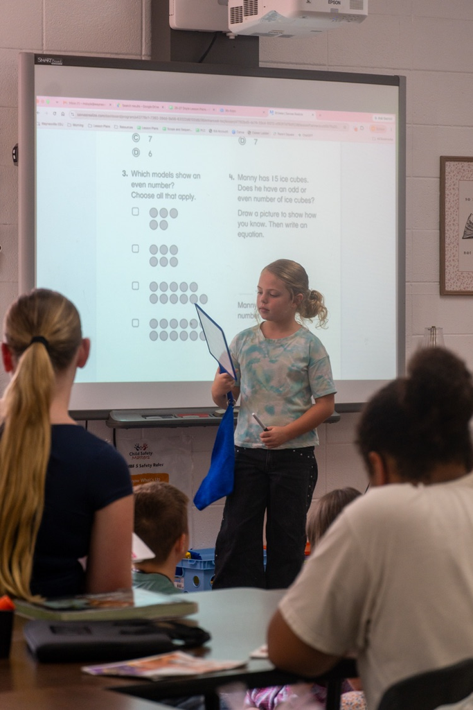 High school students watching a third grader as she answers a class question.