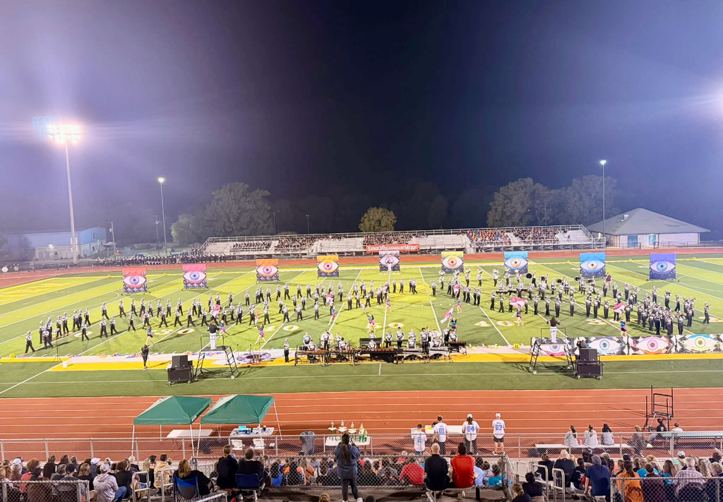 Tiger Pride Marching Band marching on a football field and playing music.