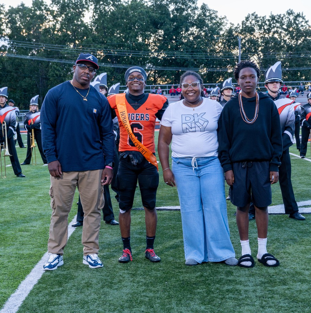 A male High School student with his mom, dad, and little brother.