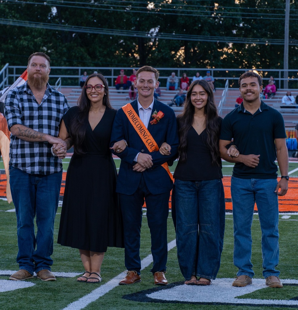 A male high school student with his mom, dad, sister, and brother.