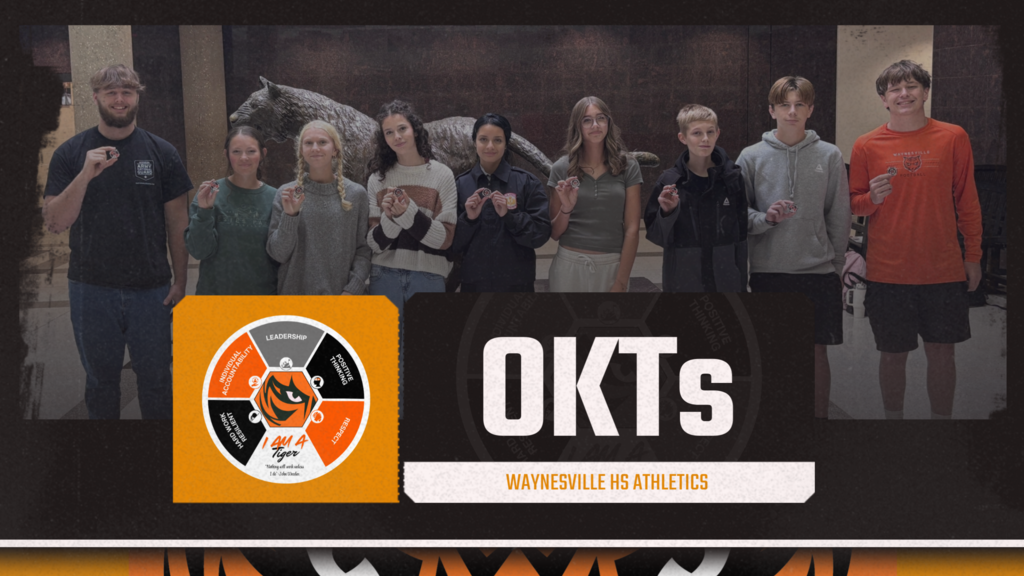 Picture of a group of students holding a Portrait of a Tiger coin, OKTs as the title with the qualities of a tiger listed.