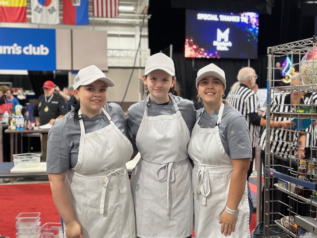 Molly McDermitt, Cycila Keeney and Samantha Etheridge dressed in aprons pose for a photo at the World Food Championships