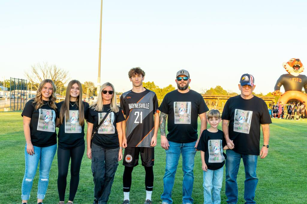 A male senior on the Waynesville soccer team being walked out on senior night by his family.
