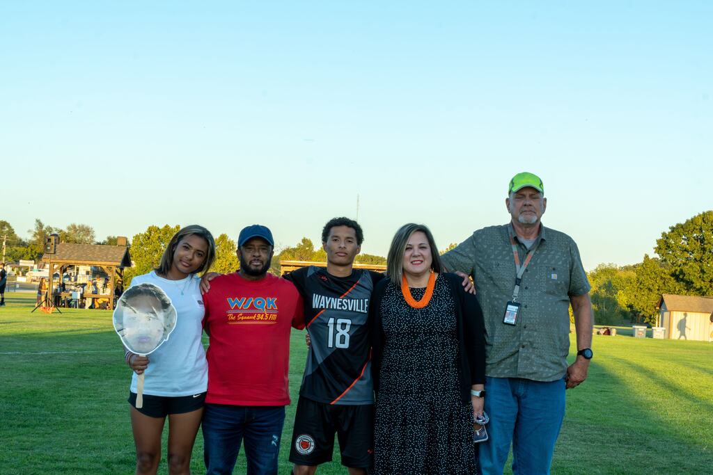 A male senior on the Waynesville soccer team being walked out on senior night by his family.