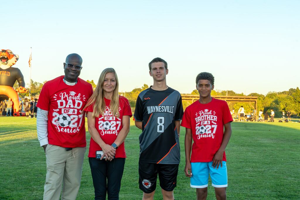 A male senior on the Waynesville soccer team being walked out on senior night by his family.