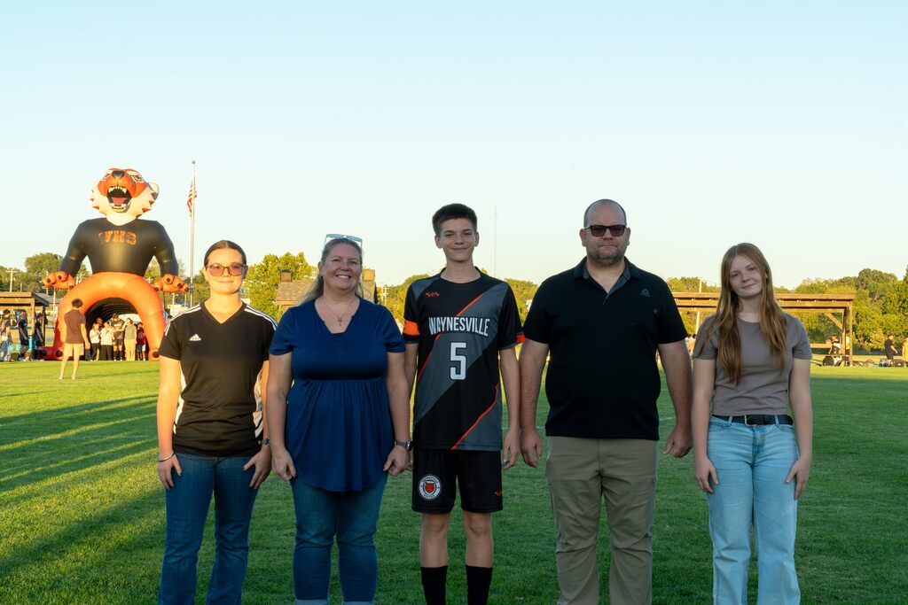 A male senior on the Waynesville soccer team being walked out on senior night by his family.
