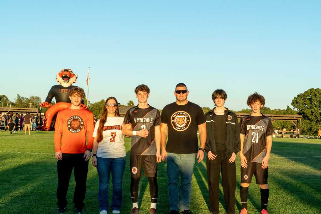 A male senior on the Waynesville soccer team being walked out on senior night by his family.