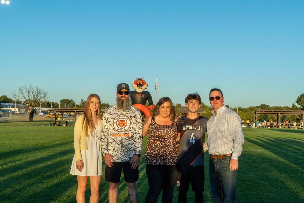 A male senior on the Waynesville soccer team being walked out on senior night by his family.