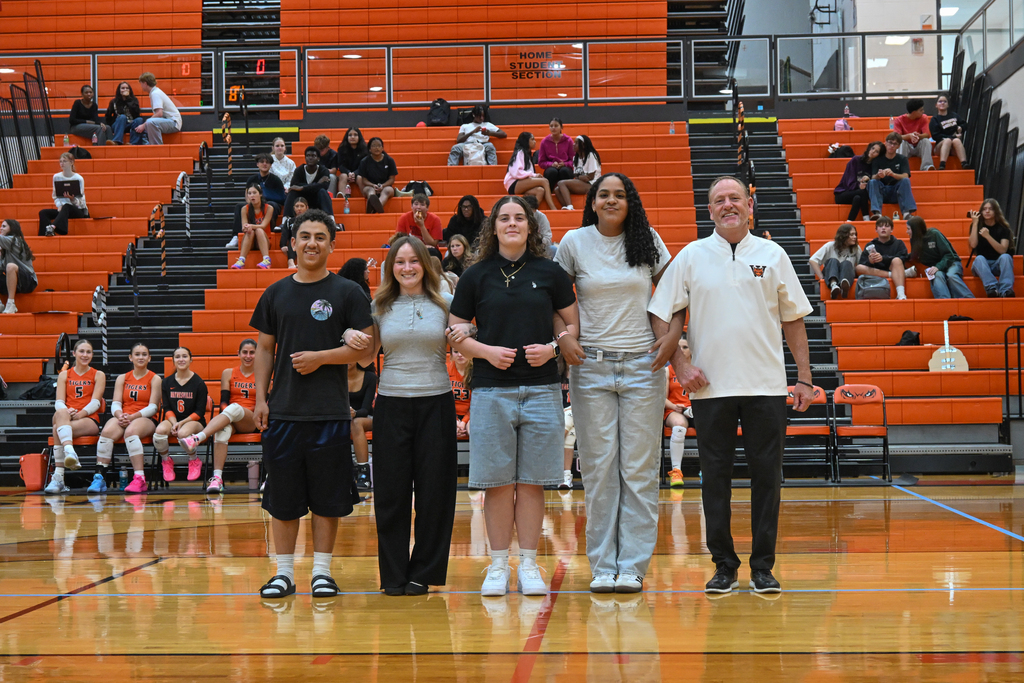 A female senior being walked out by her friends on Senior night for volleyball.