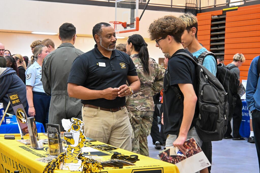 A student talking to a college recruiter.