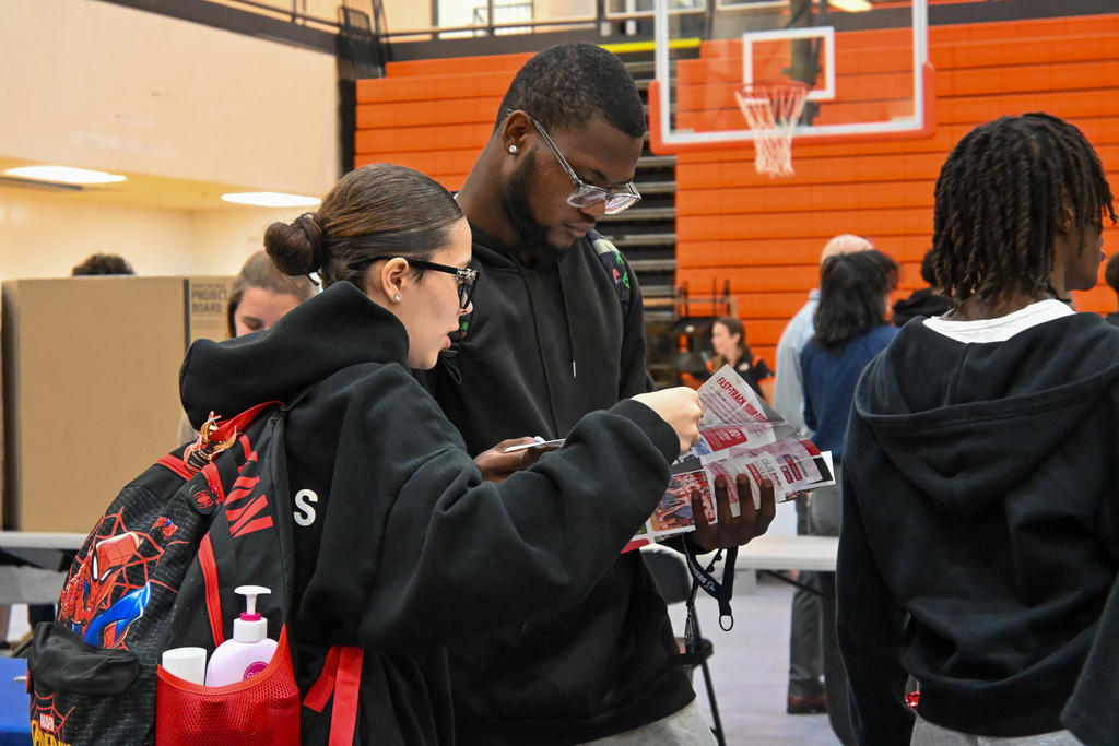 Students looking through a college pamphlet