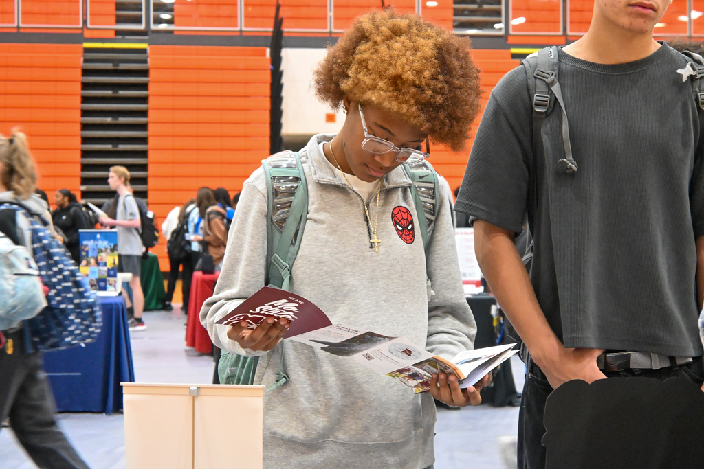 A student looking through a college pamphlet.