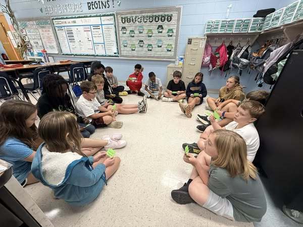 Students setting in a circle completing activity