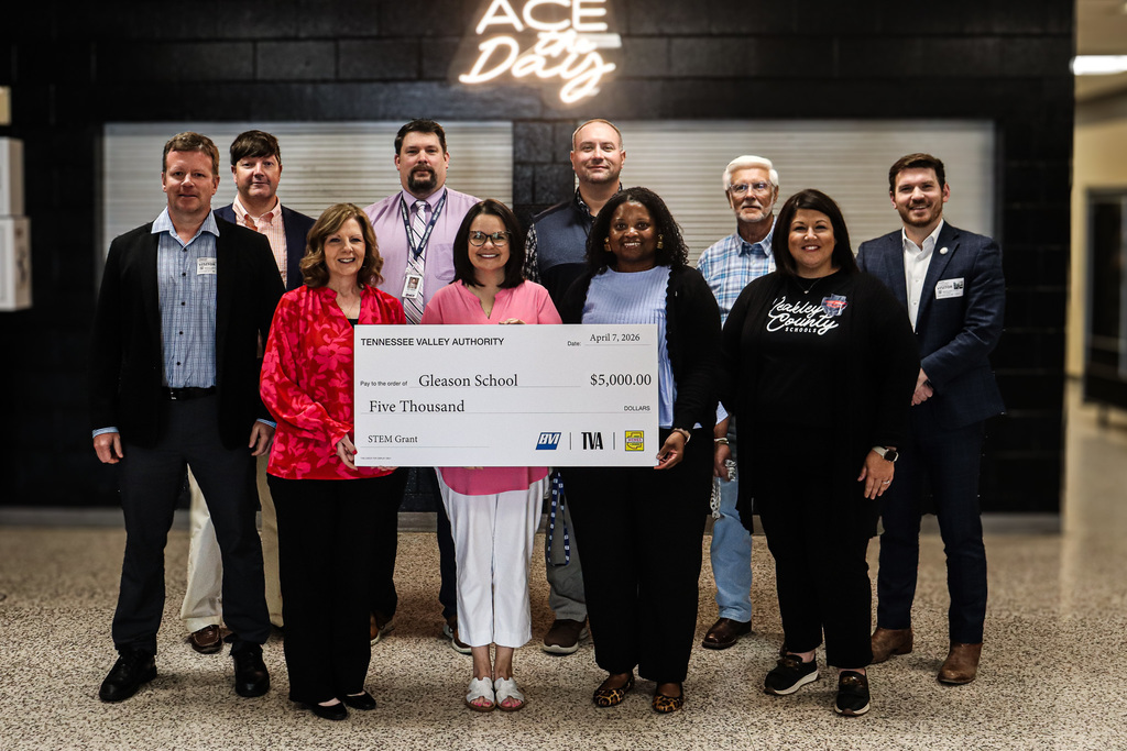 Group of school and community representatives stand together holding a large $5,000 Tennessee Valley Authority STEM grant check awarded to Gleason School.