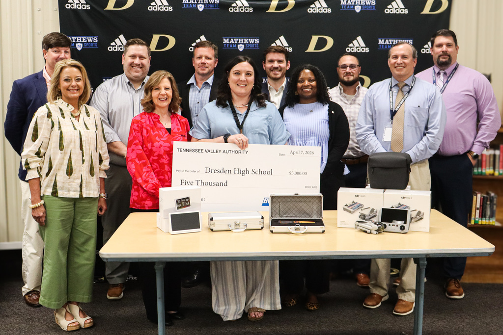 Group poses behind a table of STEM equipment while holding a $5,000 Tennessee Valley Authority grant check awarded to Dresden High School.