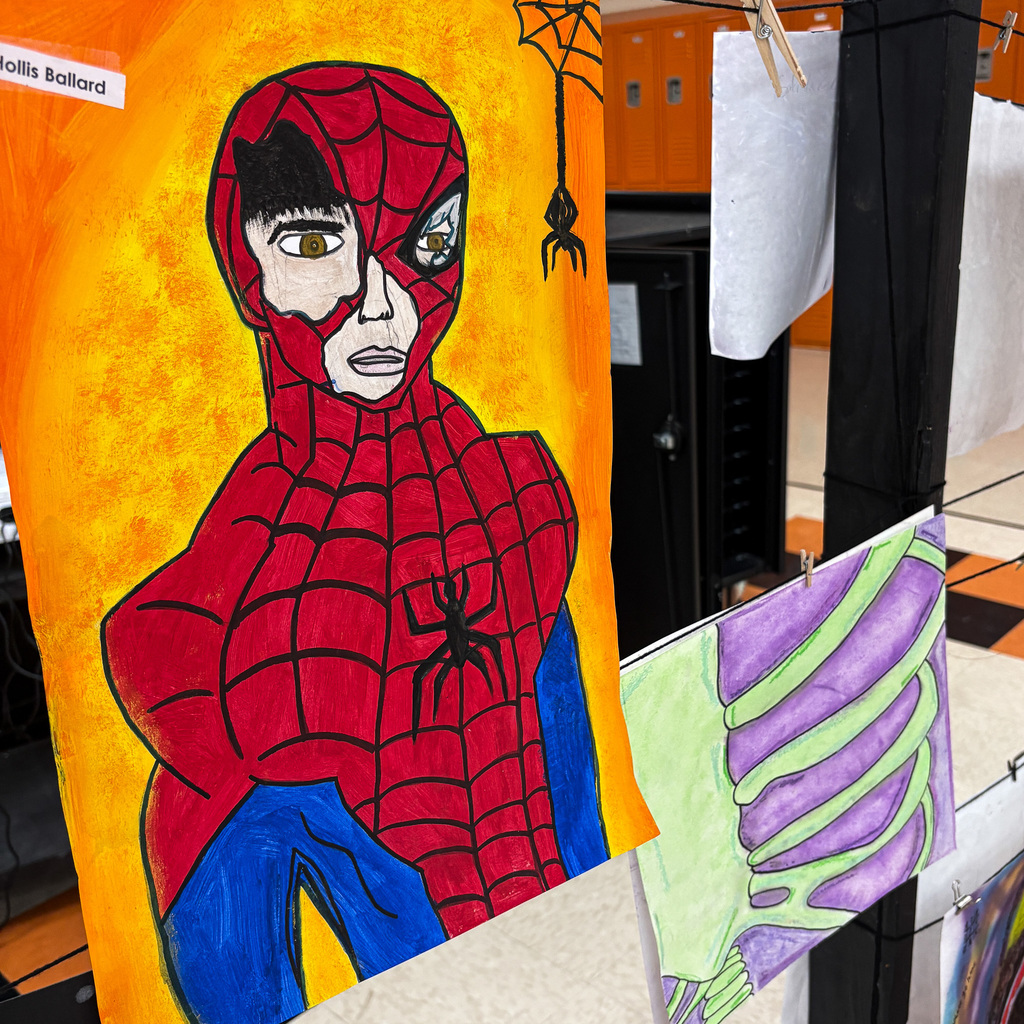 Artwork displays a Spiderman illustration on a bright yellow background. Nearby, a black spider on a web.