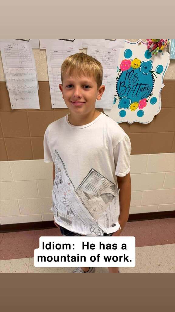 Student with worksheets in shape of a mountain on a tee shirt.