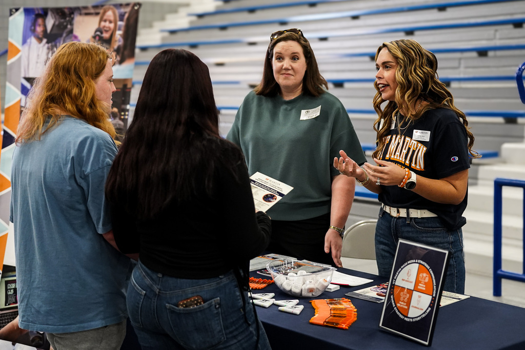 Students talk to potential colleges at a career fair.