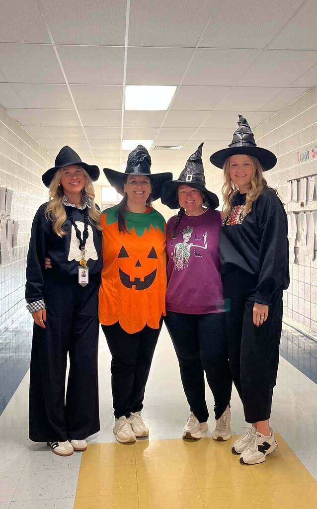 a group of teachers dress up as witches for halloween