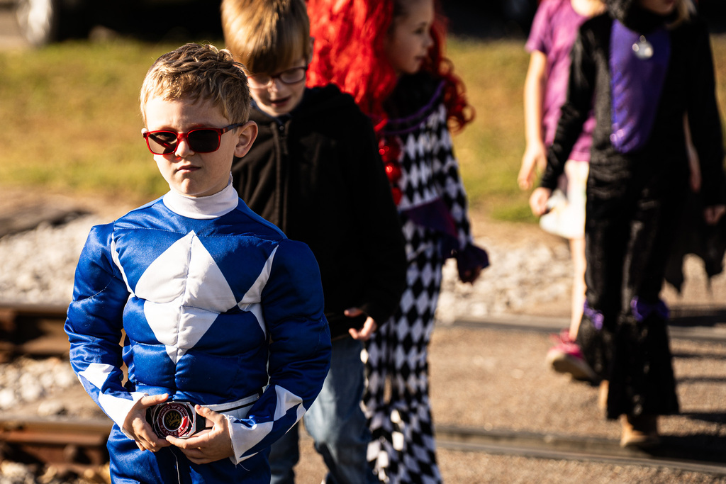 a child is trick or treating dressed as a superhero