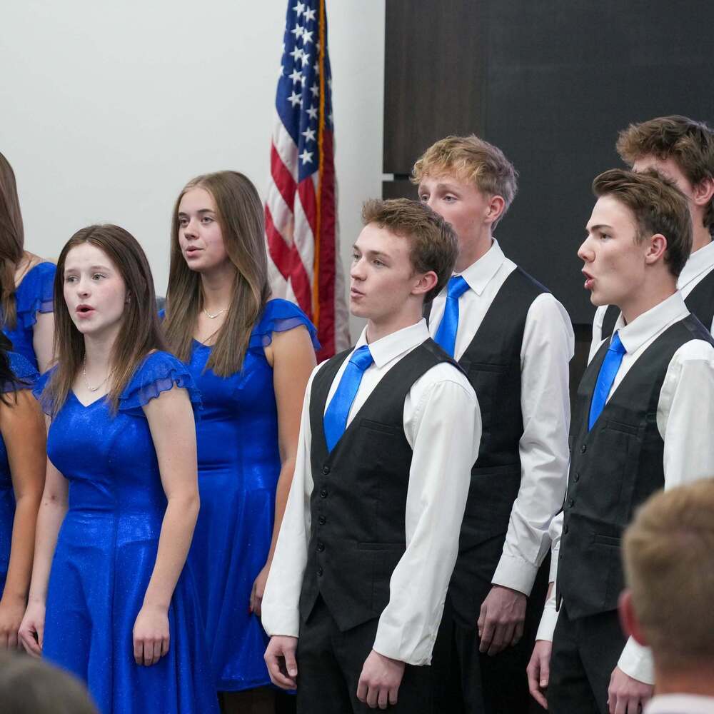Student choir singing at board meeting