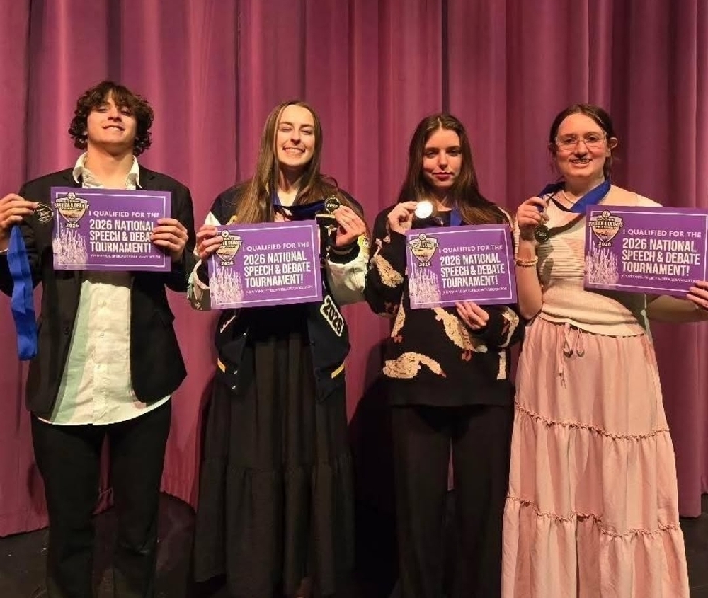 Four debate students posing with their awards after a recent Speech and Debate tournament. 