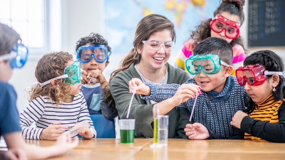 students with a teacher and beakers doing science