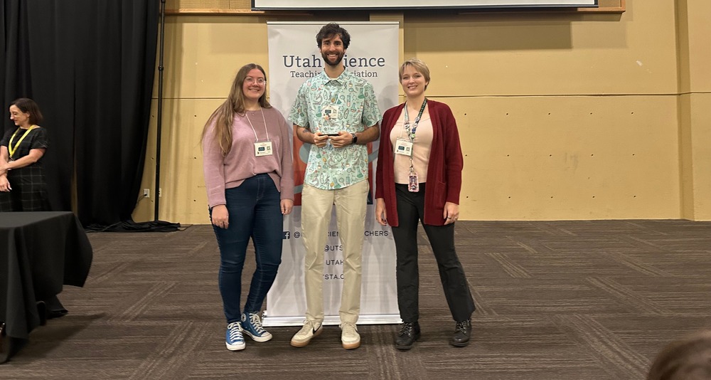 three people holding an award