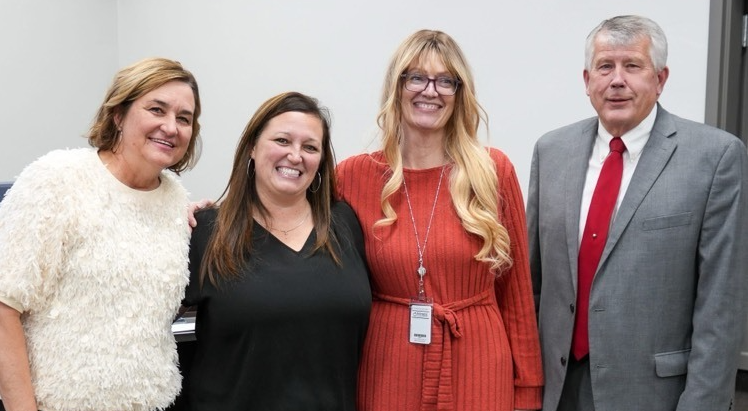 teacher surrounded by school board members 