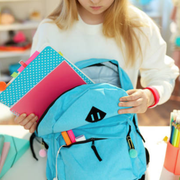 A student putting things away in their backpack