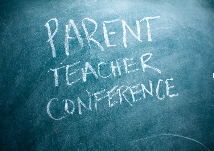 Chalkboard with the words Parent Teacher Confrence written on it.
