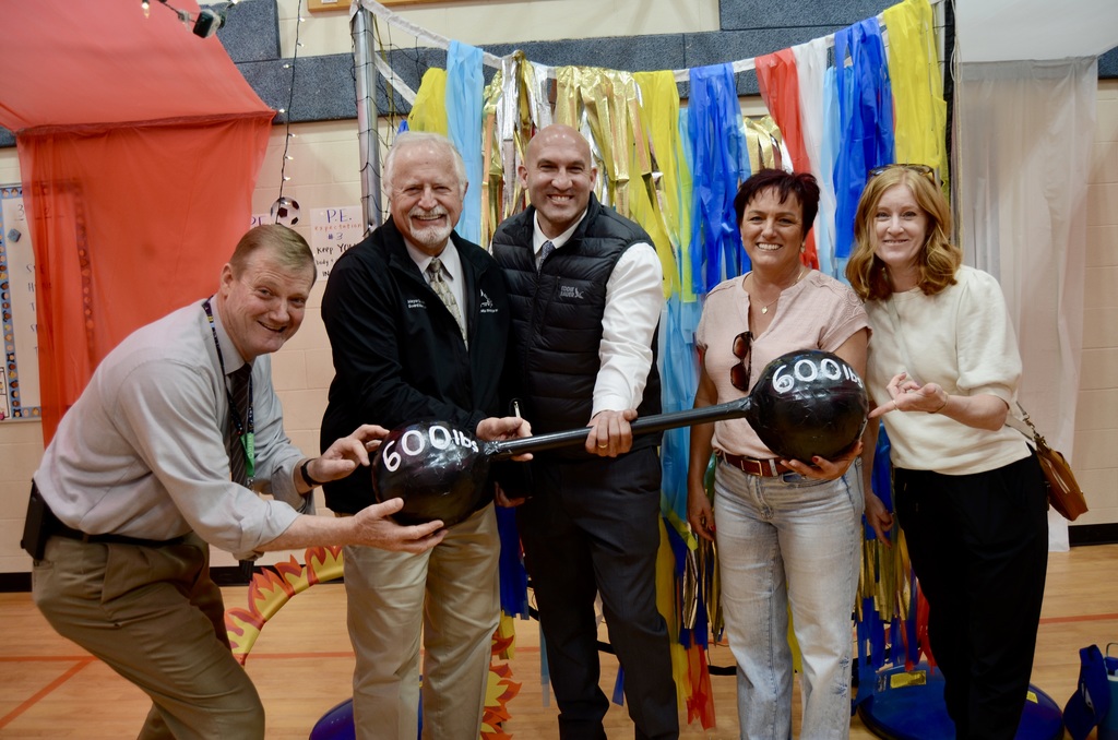 Roy City Mayor and District Leaders of Weber School District celebrating All Abilities Day holding a  pretend weight together