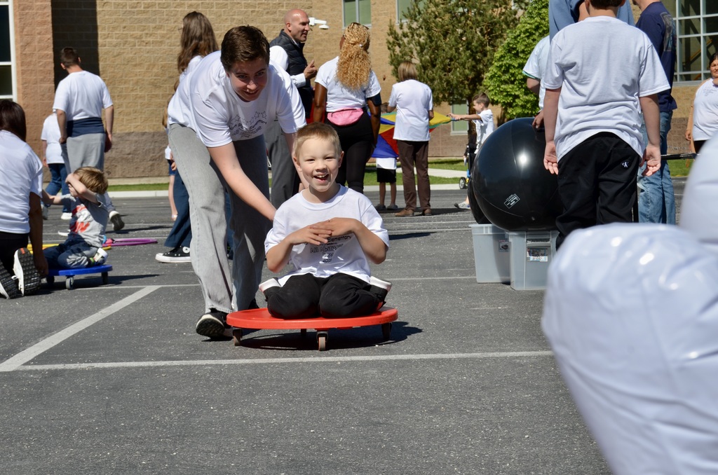 child being pushed on a scooter