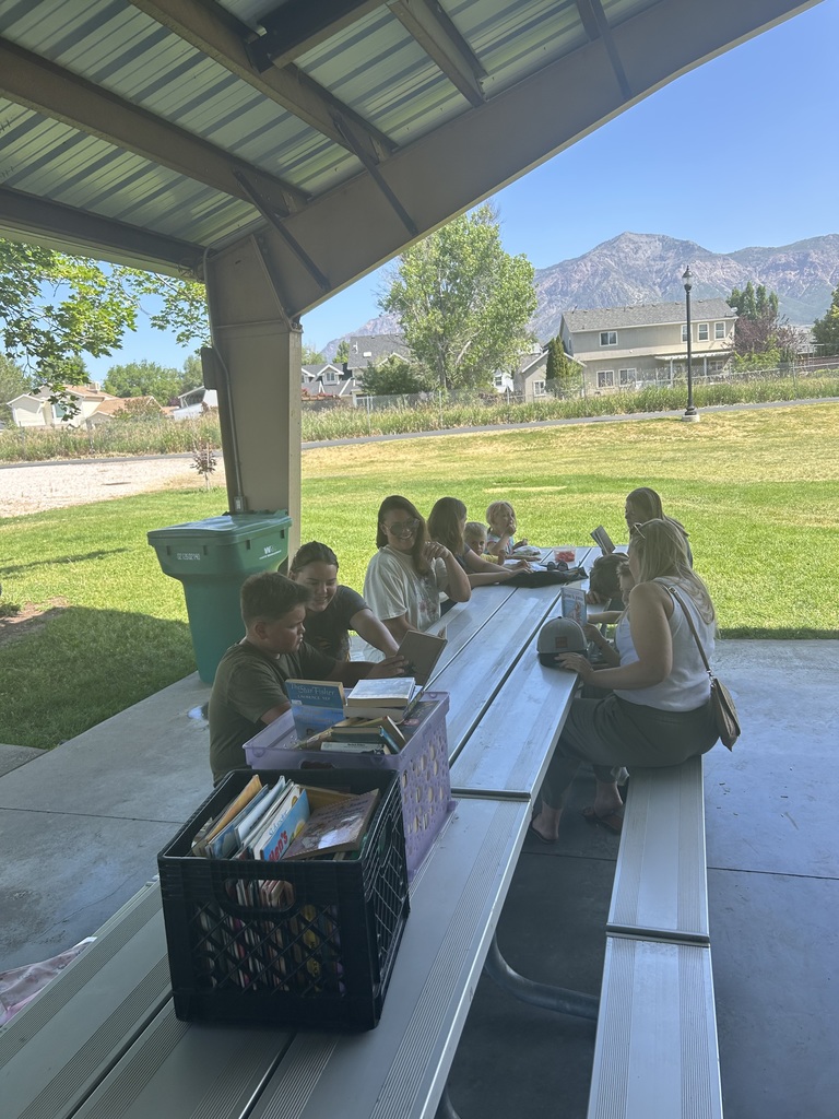 Pioneer students reading at the park.