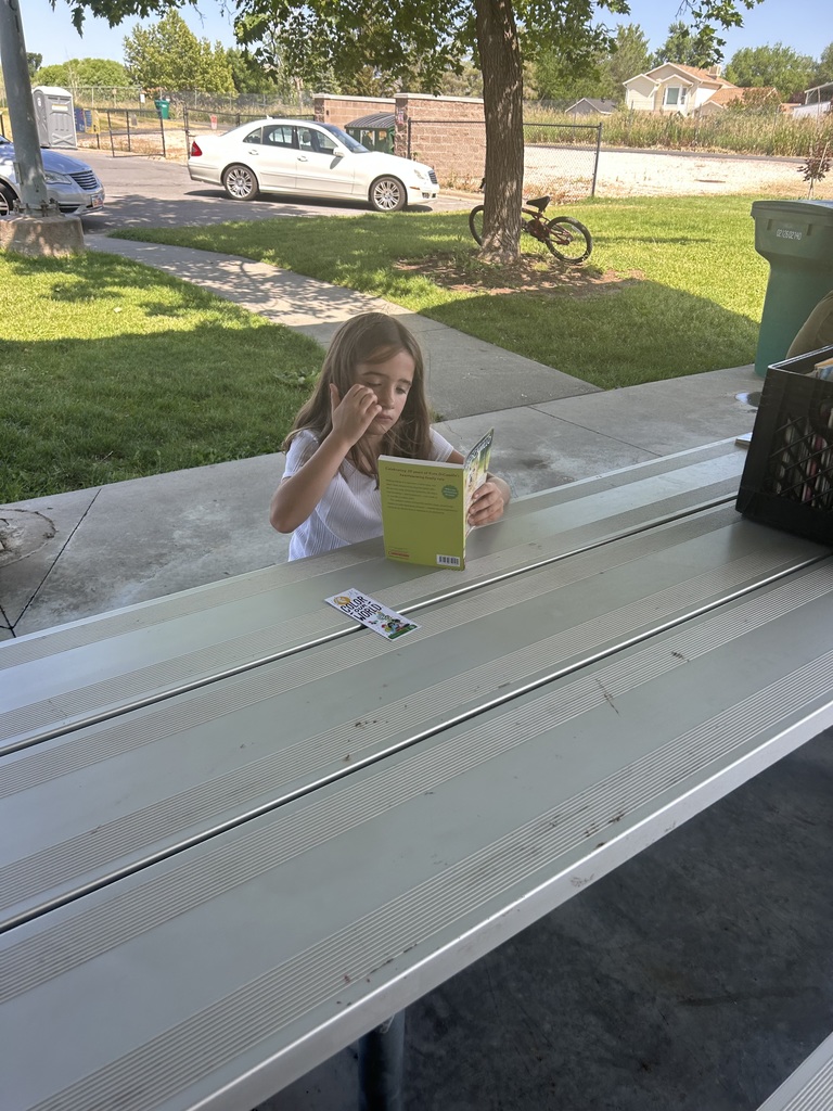 Pioneer student reading at the park.