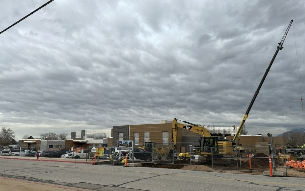 the process of the roosevelt rebuild- there is brick on the building now- a crane and a excavator out front