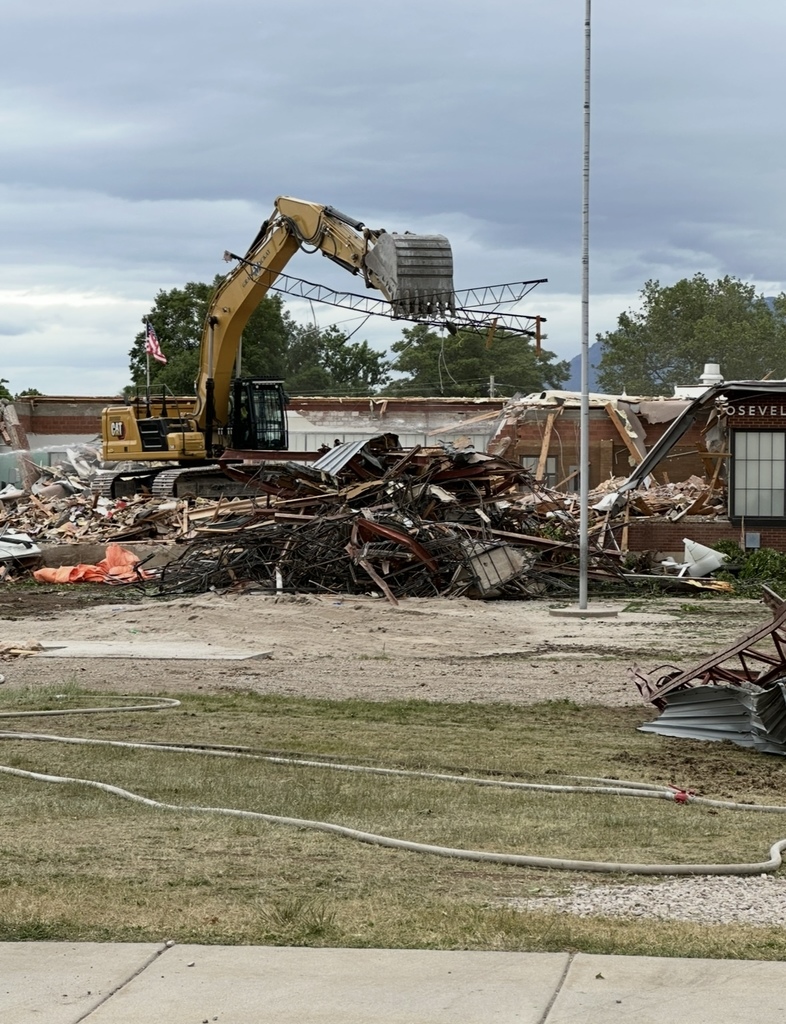the old roosevelt elementary building is being torn down by an excavator- the