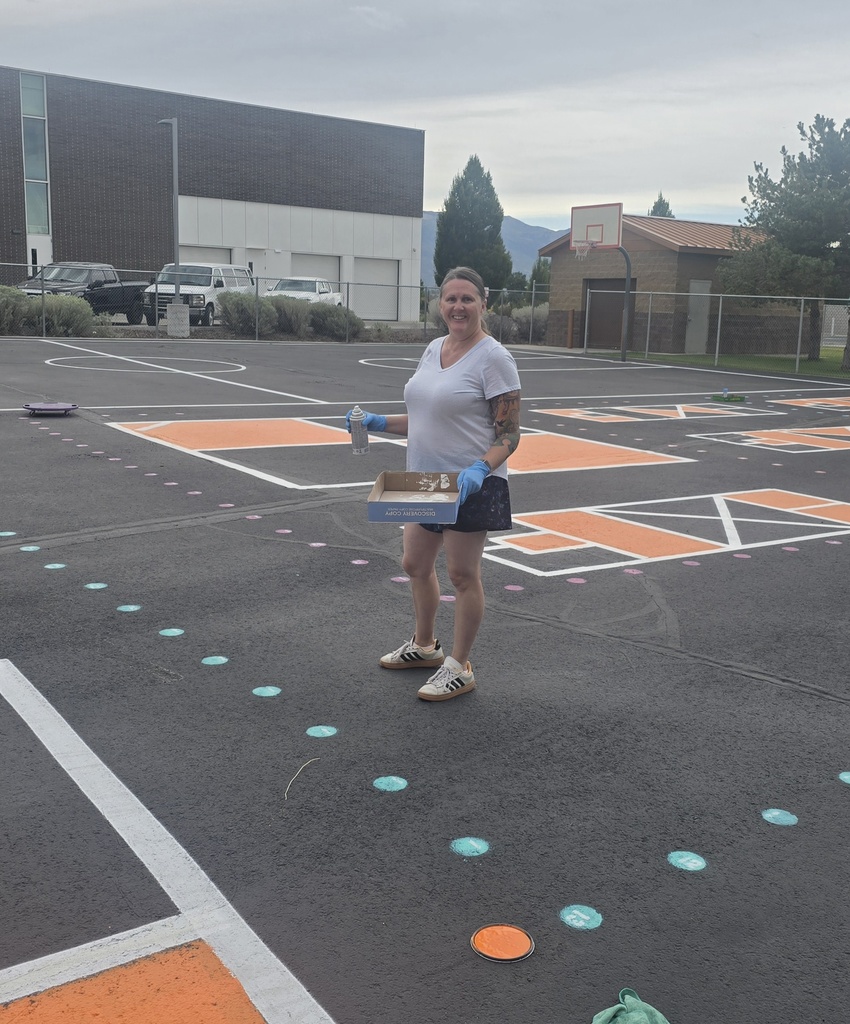 Custodian with a box template for painting the playground.