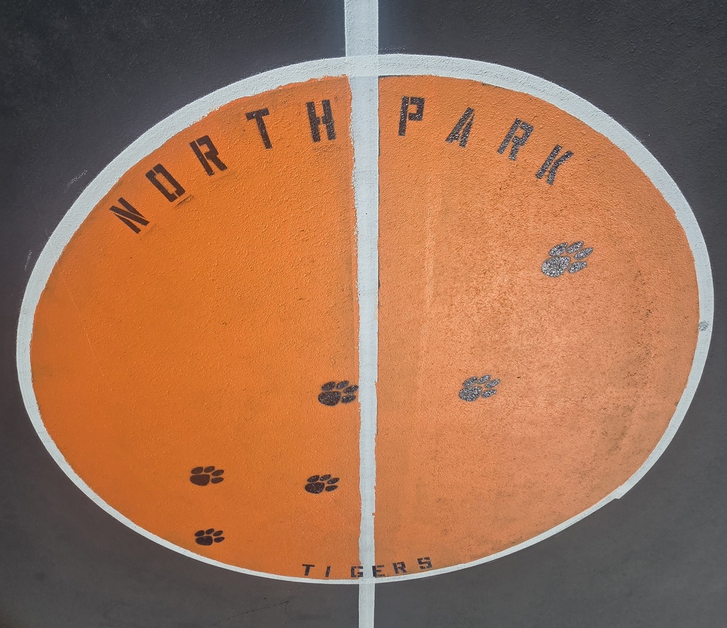 Round orange circle with North Park Tigers and paw prints