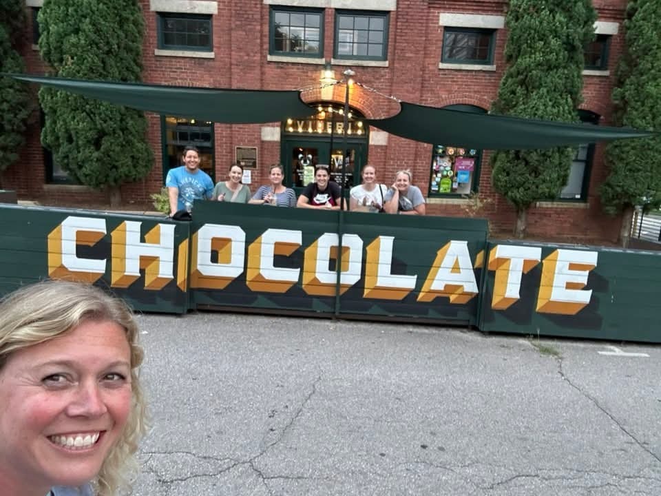 Teachers in front of a chocolate sign