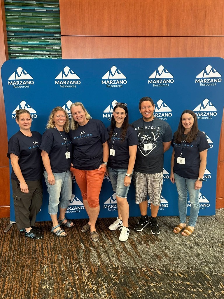 Teachers in front of a sign for Marazno Teacher Conference