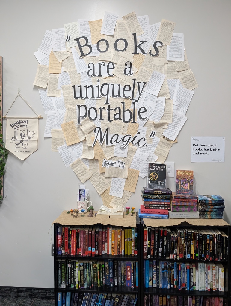 Photograph of a classroom book display  at Roy Jr that says "Books are a uniquely portable magic"