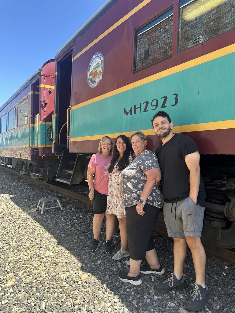 Mrs. Taurone and family in front of a train.