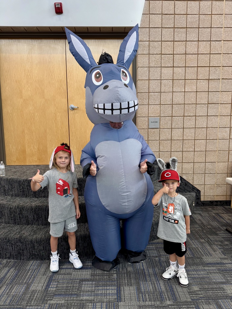 two students doing thumbs up smiling with Miss G wearing a donkey costume